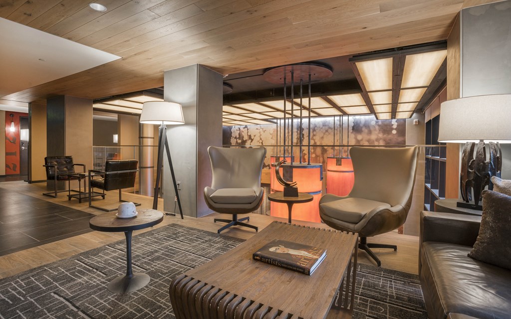 the lobby of a hotel with chairs and a table