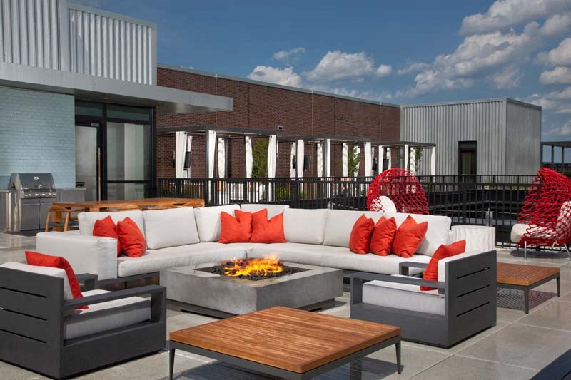 a patio with couches and chairs and a fire pit