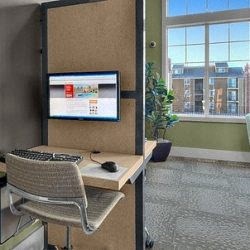 a desk with a keyboard and a monitor in an office