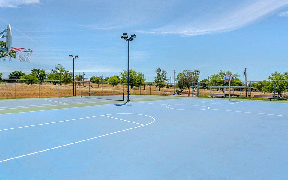 a blue tennis court with a basketball hoop on it