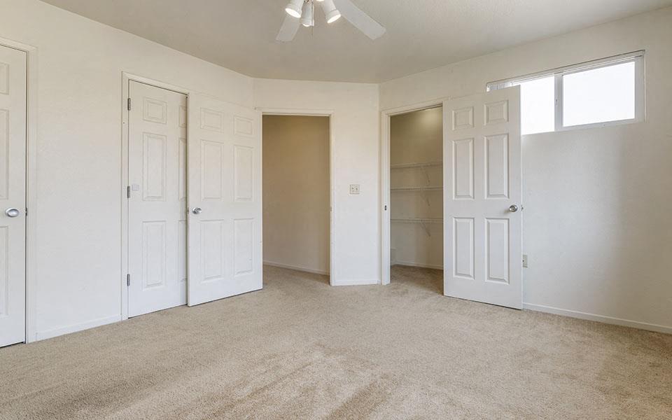 an empty living room with white doors and a closet