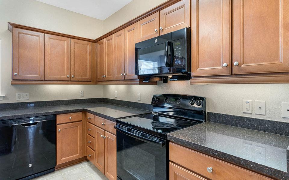 a kitchen with black appliances and wooden cabinets