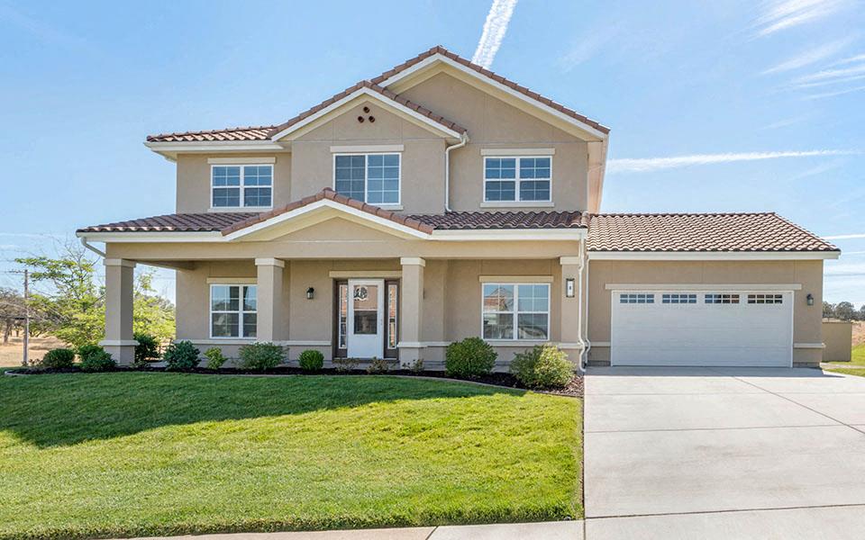 a house with a driveway and lawn in front of it