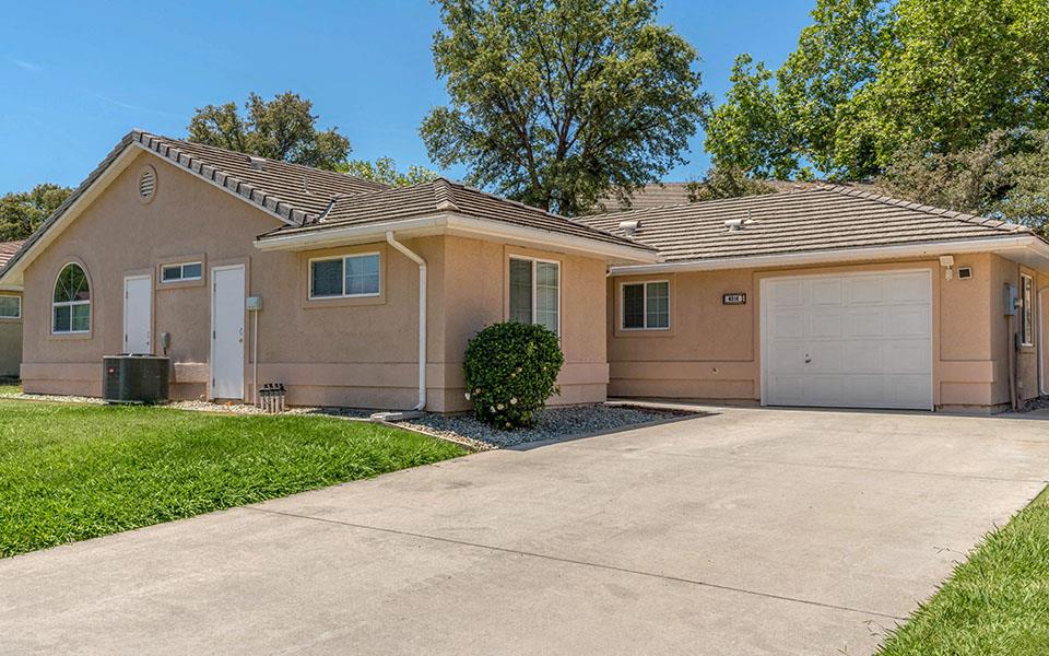 a beige house with a garage and a driveway