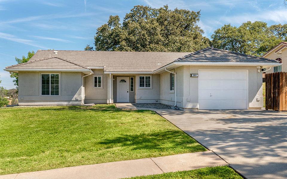 a white house with a lawn and a driveway