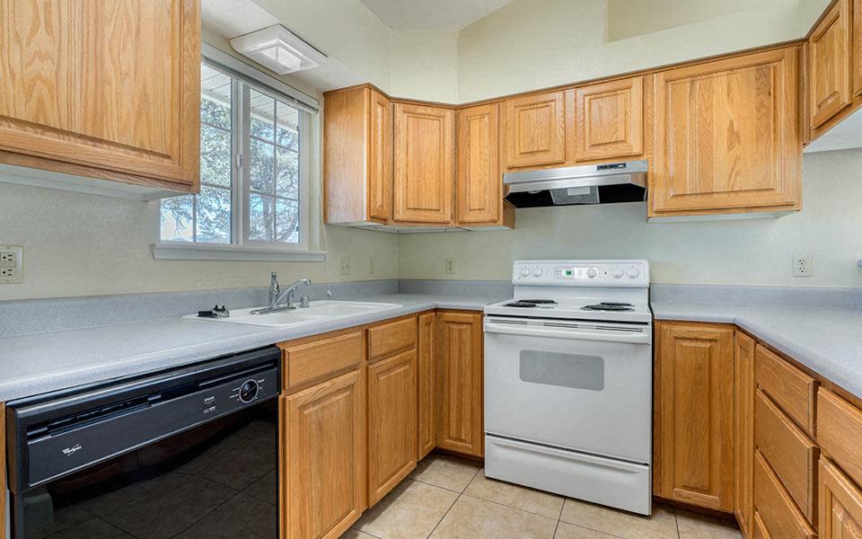 a kitchen with white appliances and wooden cabinets
