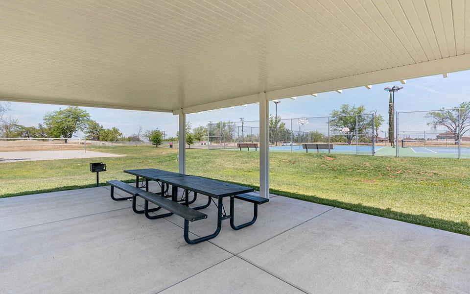 a picnic table sitting under a covered pavilion