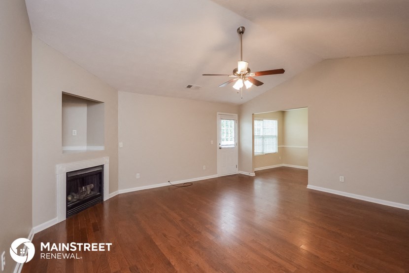 the living room with fireplace and ceiling fan
