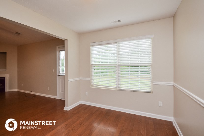 the interior of an empty room with wood floors and a large window