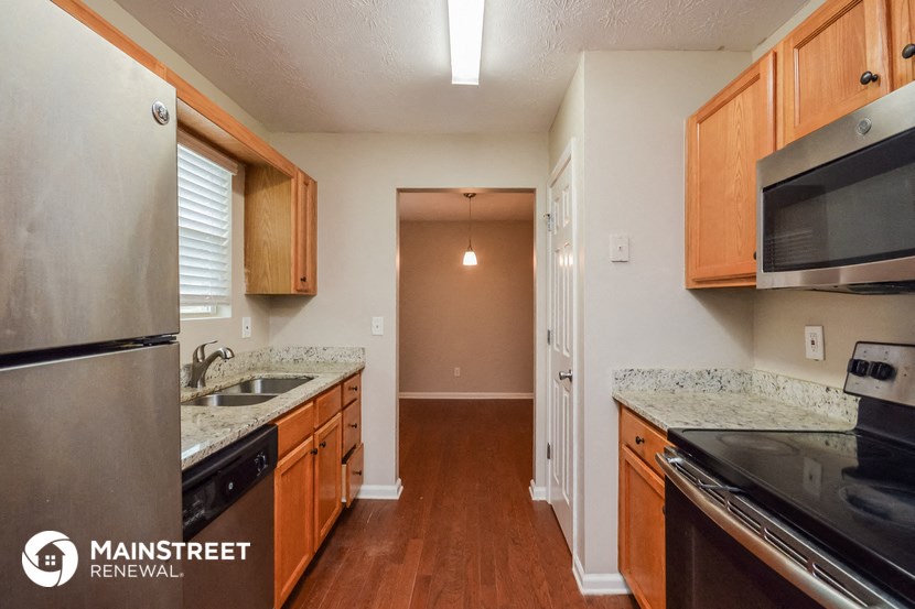 a kitchen with wooden cabinets and stainless steel appliances and granite counter tops