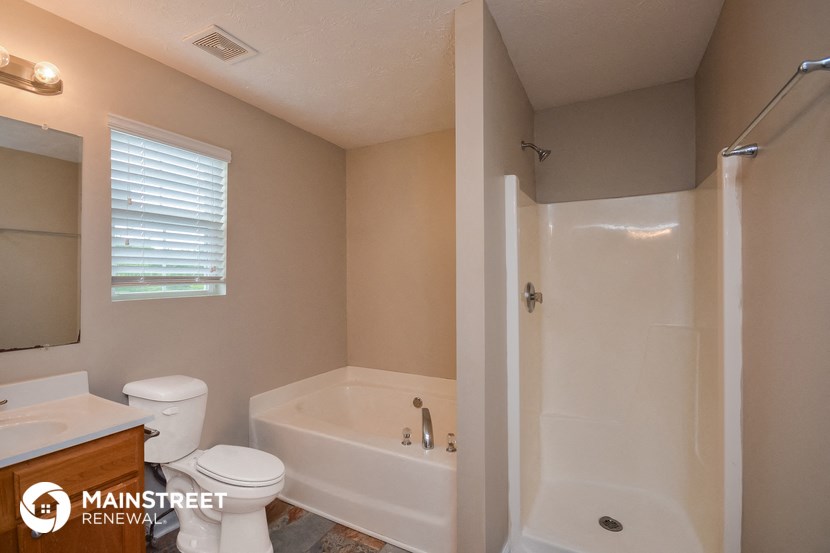 the bathroom has a large tub and a toilet and a sink