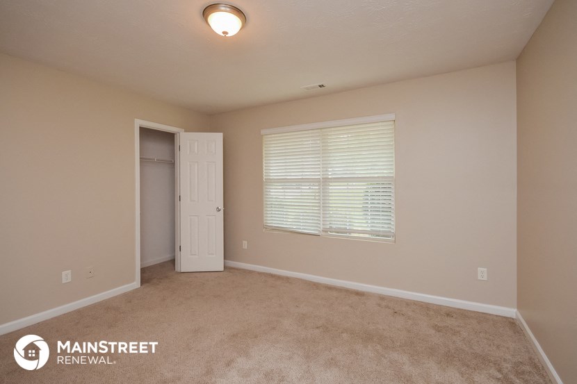the upstairs bedroom with a door to the closet and a window