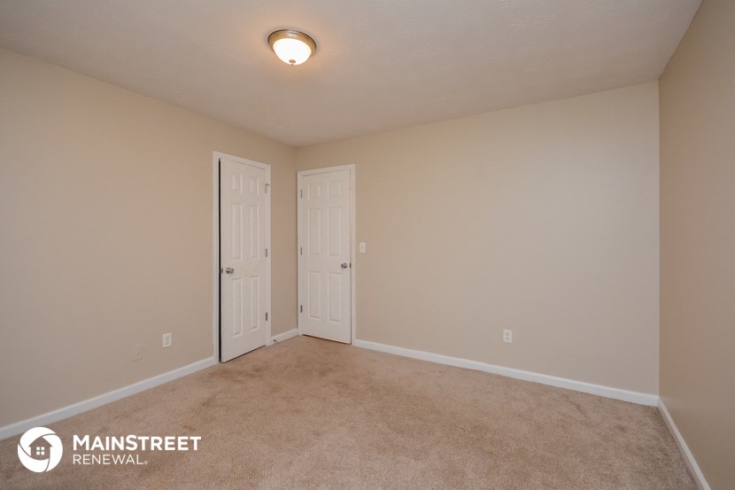 the spacious living room with two doors to the closet