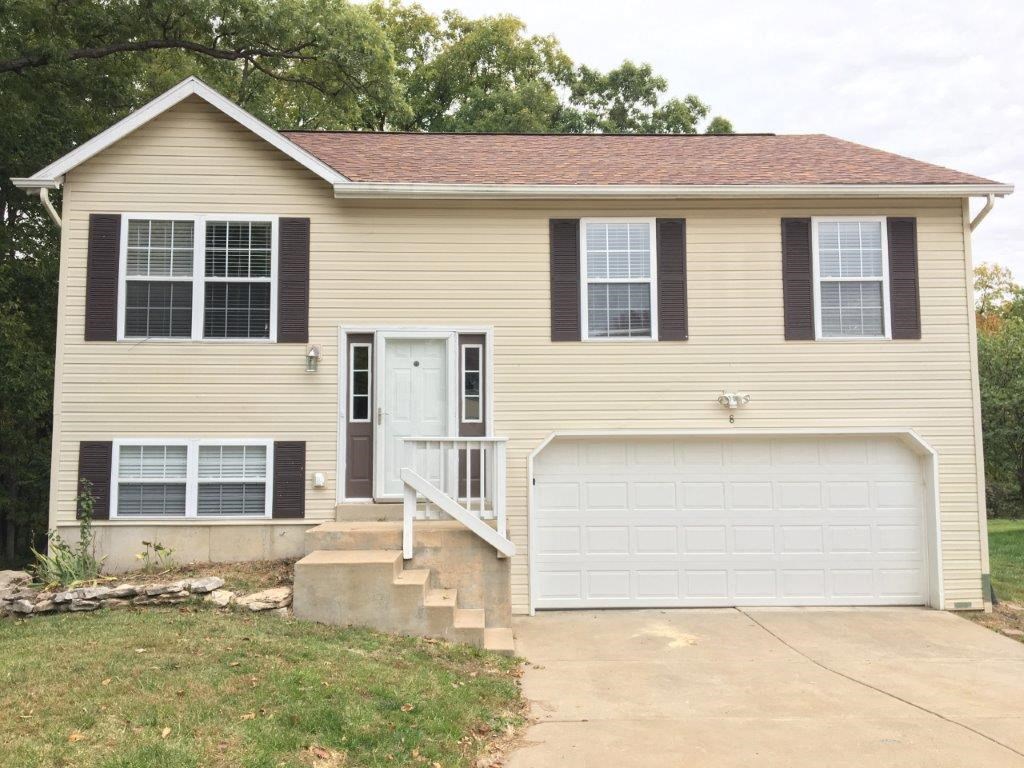 a tan house with a white garage door