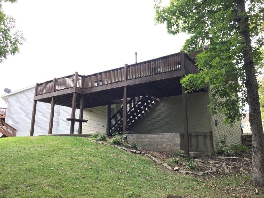 a house with a deck on top of a hill