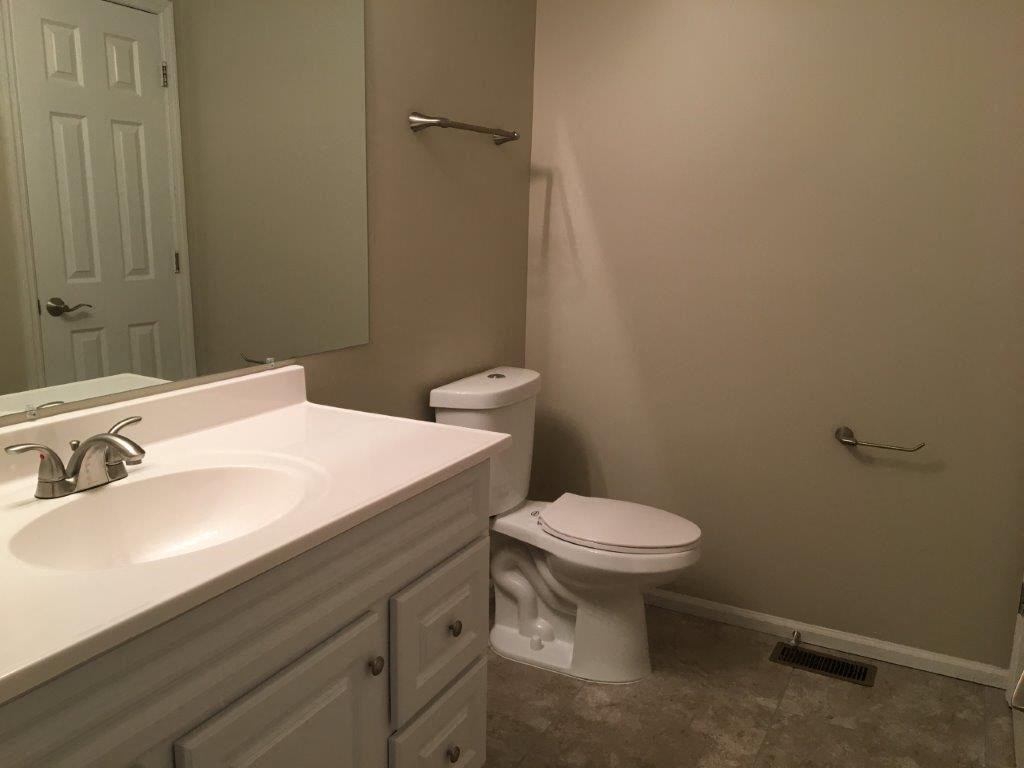 a bathroom with a toilet and a sink and a mirror