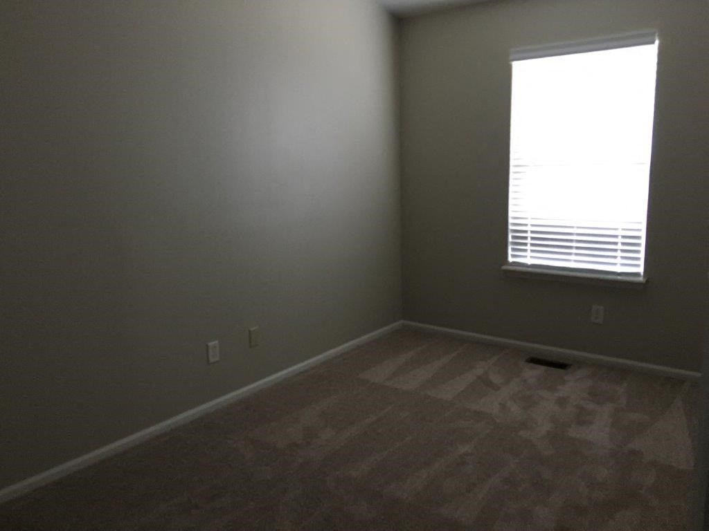 an empty room with a window and wooden floors