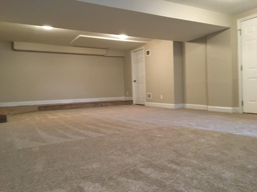 an empty room with a carpeted floor and a door