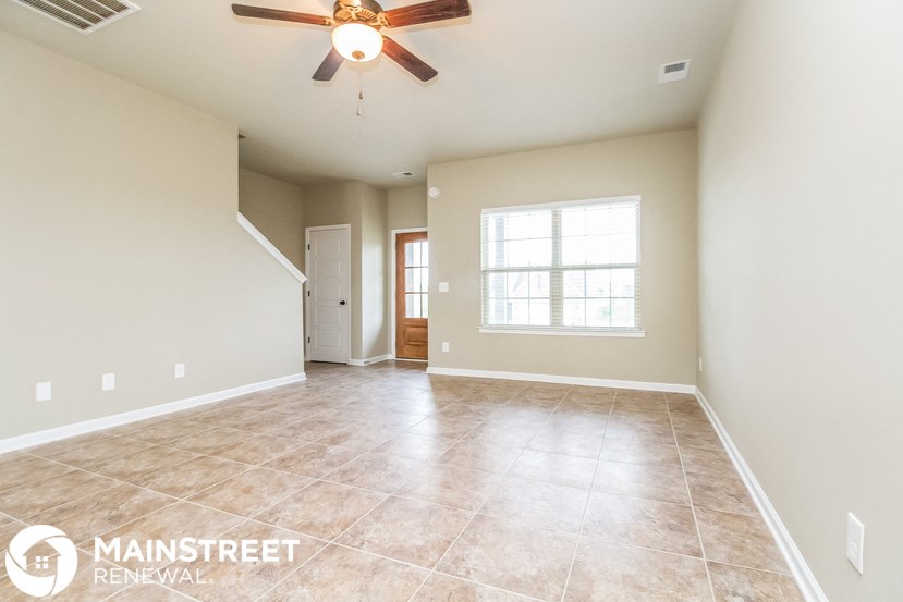 the spacious living room is open to the dining room and kitchen