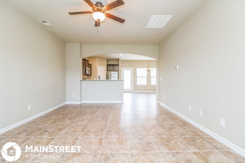 an empty kitchen and living room with a ceiling fan