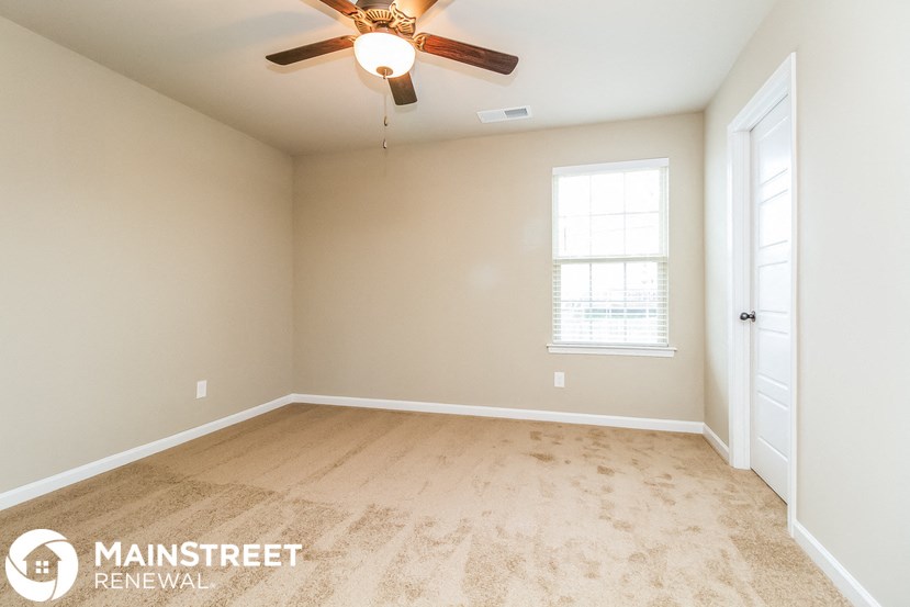 the master bedroom is spacious and clean with a ceiling fan