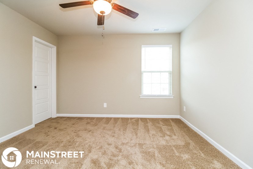 an empty room with a ceiling fan and a window