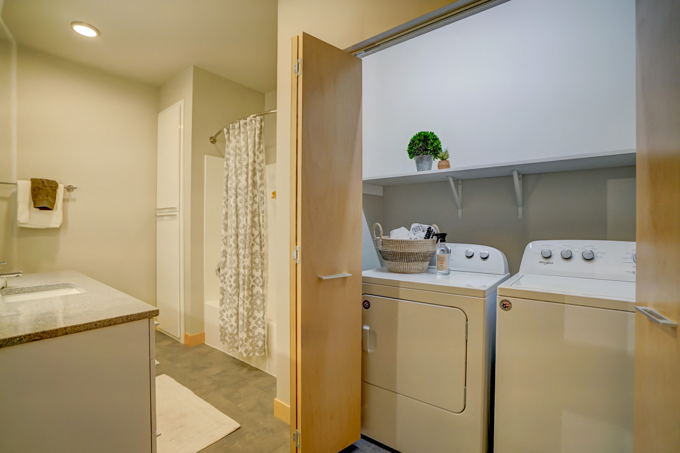 a washer and dryer in a laundry room with a door to the bathroom