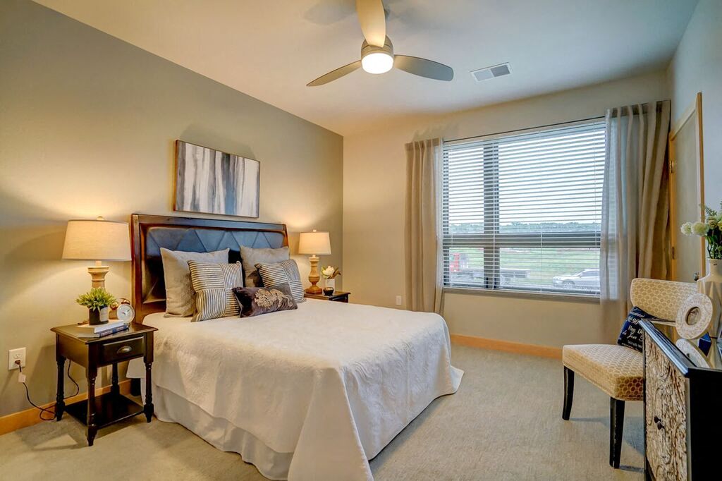 a bedroom with a large bed and a ceiling fan
