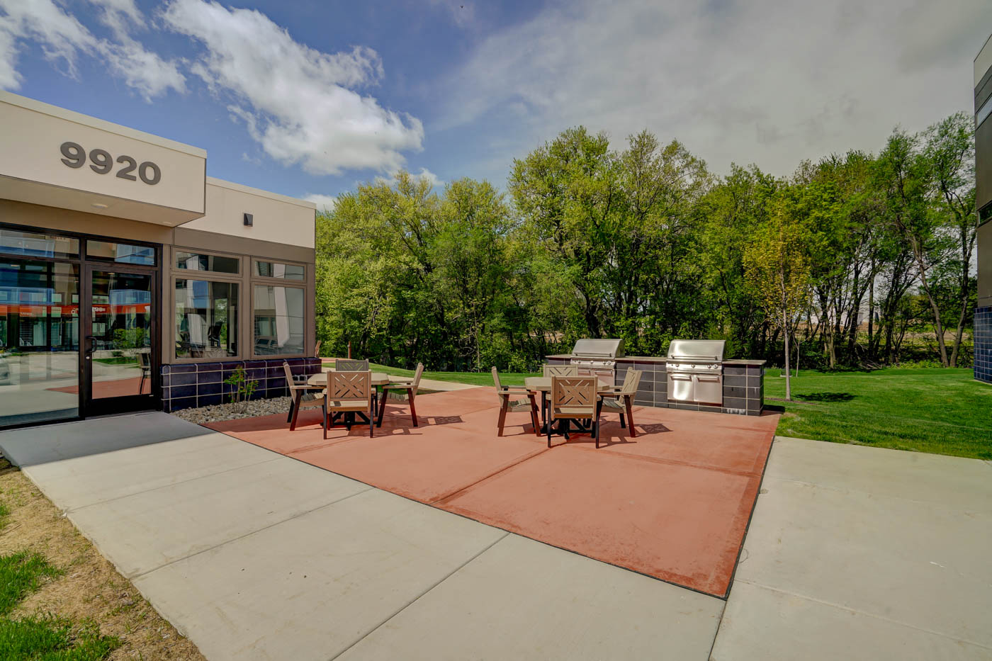 a patio with furniture and a fire pit in front of a building