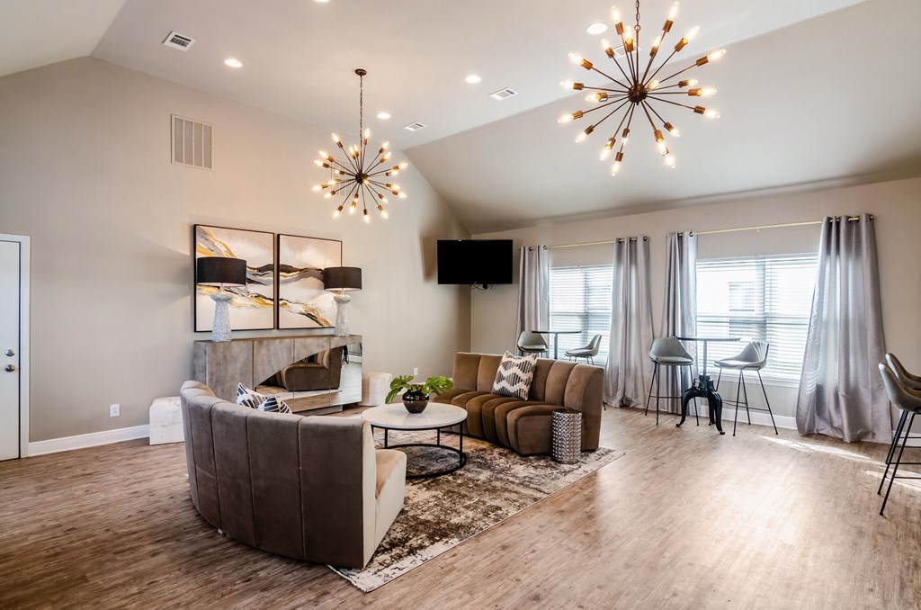 a living room with a couch and a chair and a chandelier