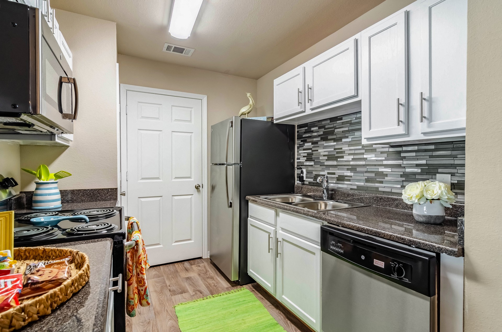 a kitchen with white cabinets and a stainless steel refrigerator