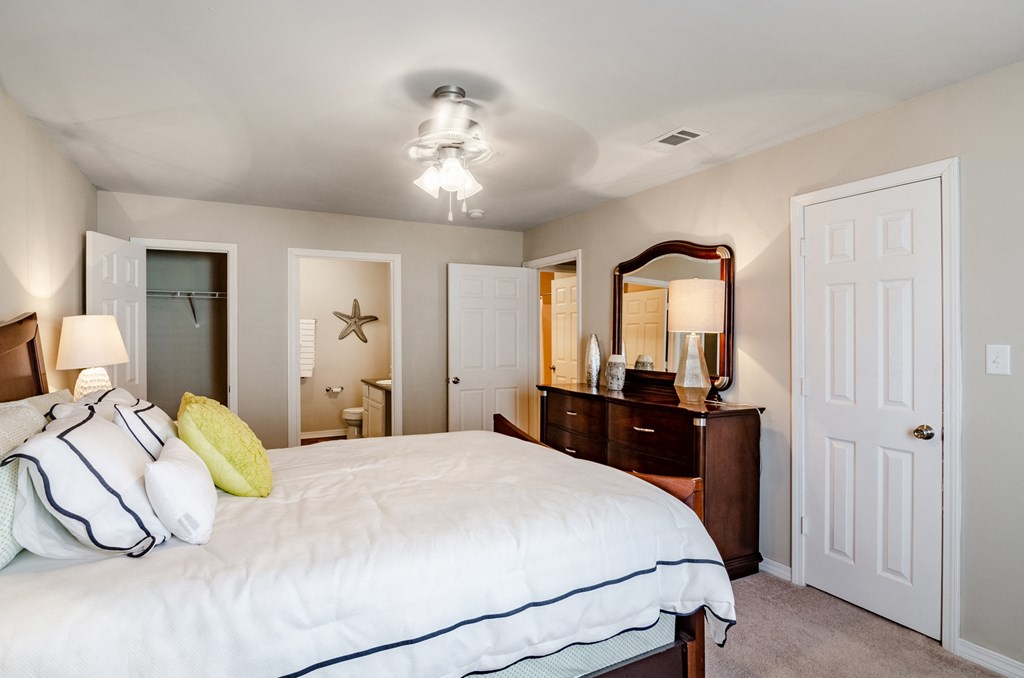 a bedroom with a bed and a dresser and a closet