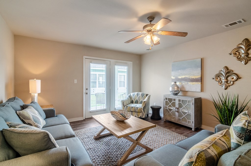 a living room with a couch and a coffee table and a ceiling fan