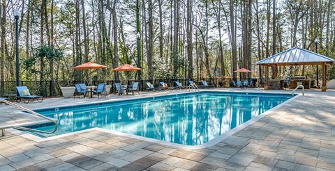 the swimming pool is surrounded by chairs and umbrellas