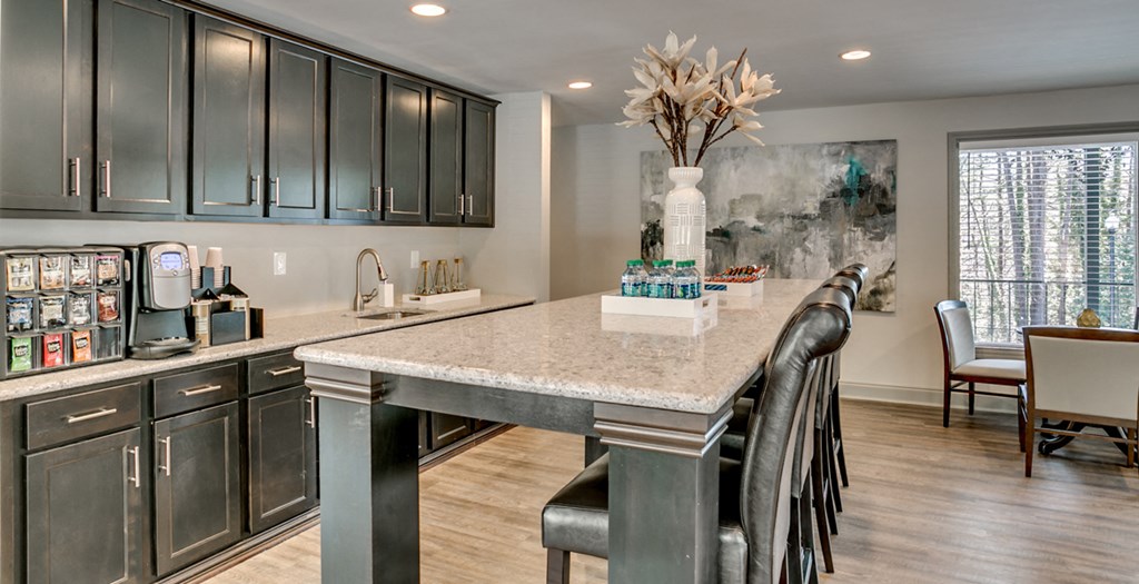 a kitchen with a marble counter top and a bar with chairs