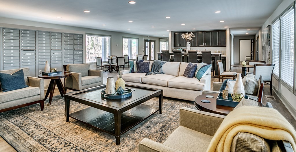 a living room with couches and chairs and a dining room with a kitchen