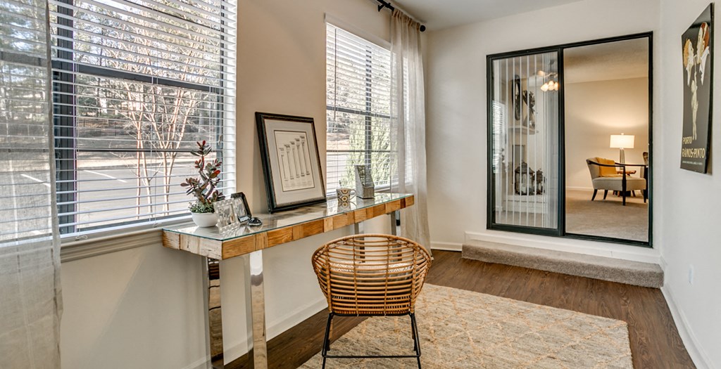 a home office with a desk and a chair in front of a window