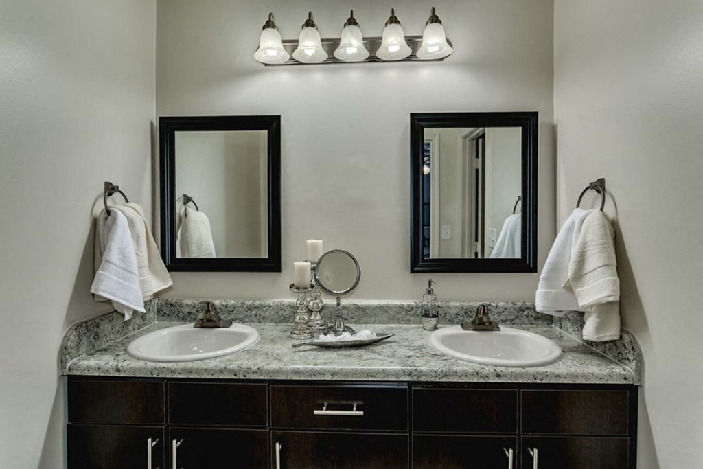 a bathroom with two sinks and two mirrors