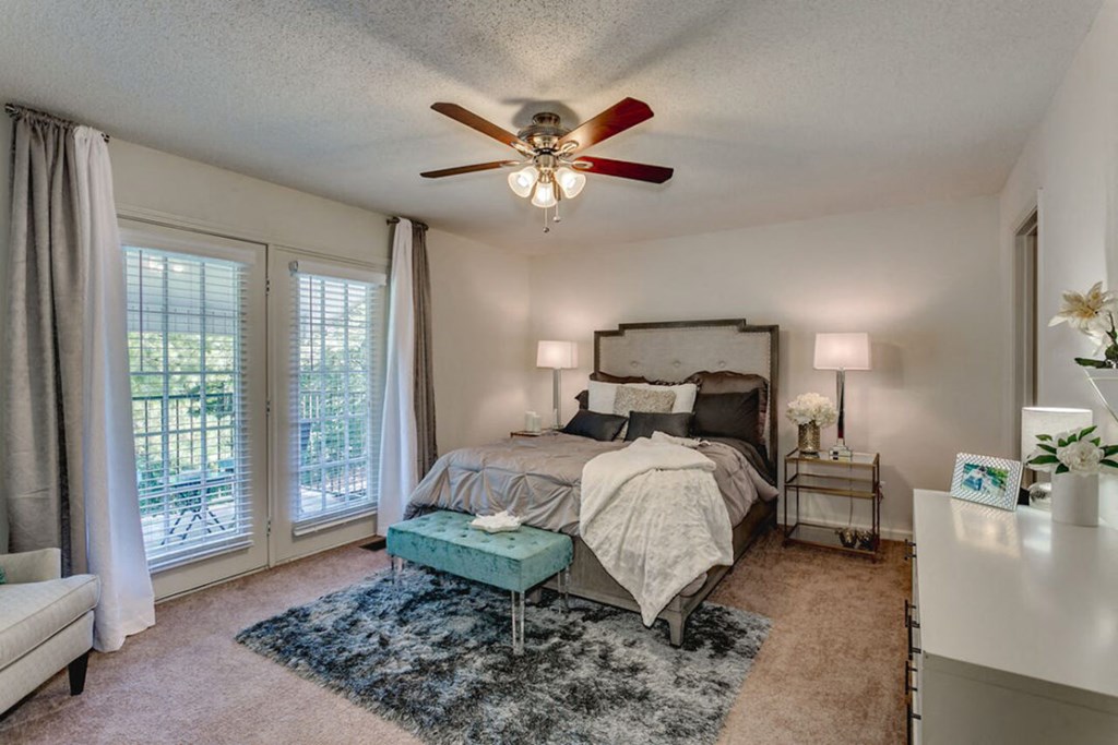a bedroom with a bed and a ceiling fan