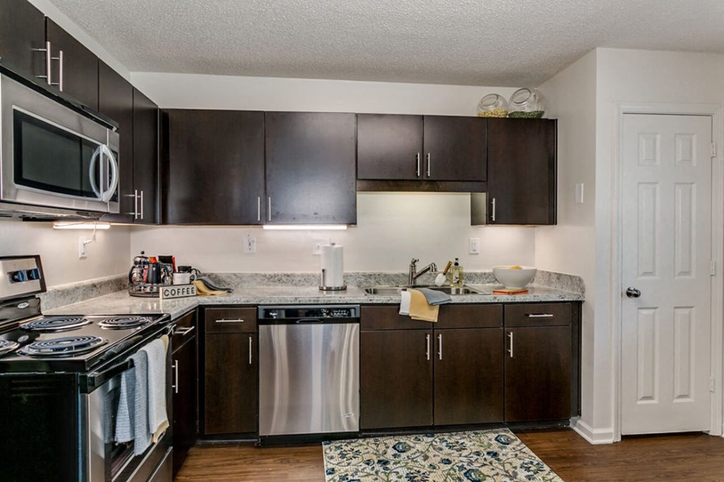 a kitchen with dark wood cabinets and stainless steel appliances