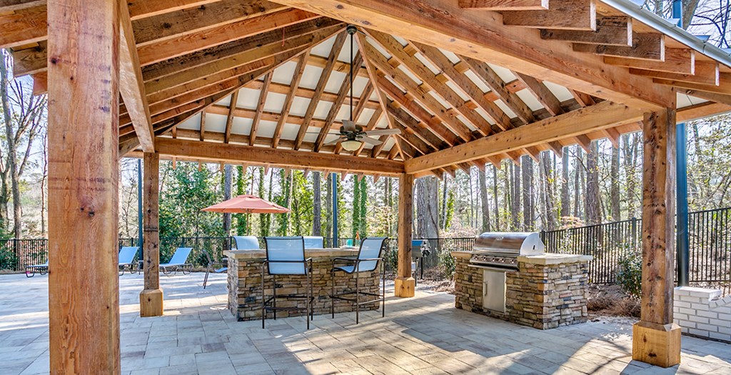 a patio with a stone fireplace and a wooden roof