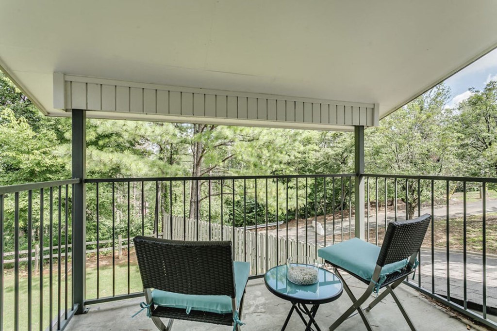 a patio with two chairs and a table on a balcony