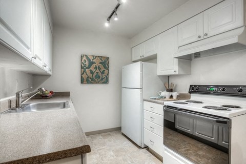 a kitchen with a stove refrigerator and sink