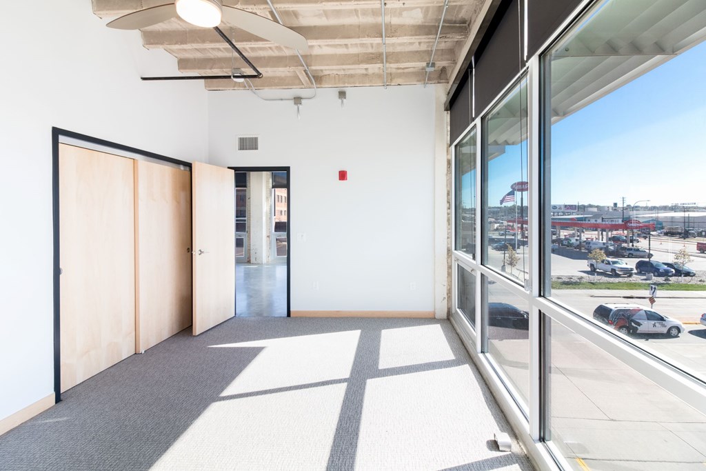 a room with a large window and a door and a view of a street