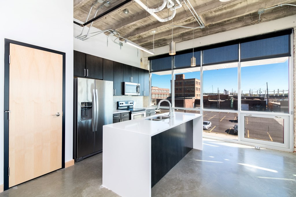 a kitchen with a large window and a white counter top