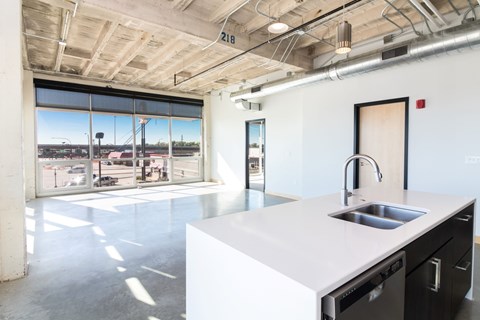 a large white kitchen with a sink and a window
