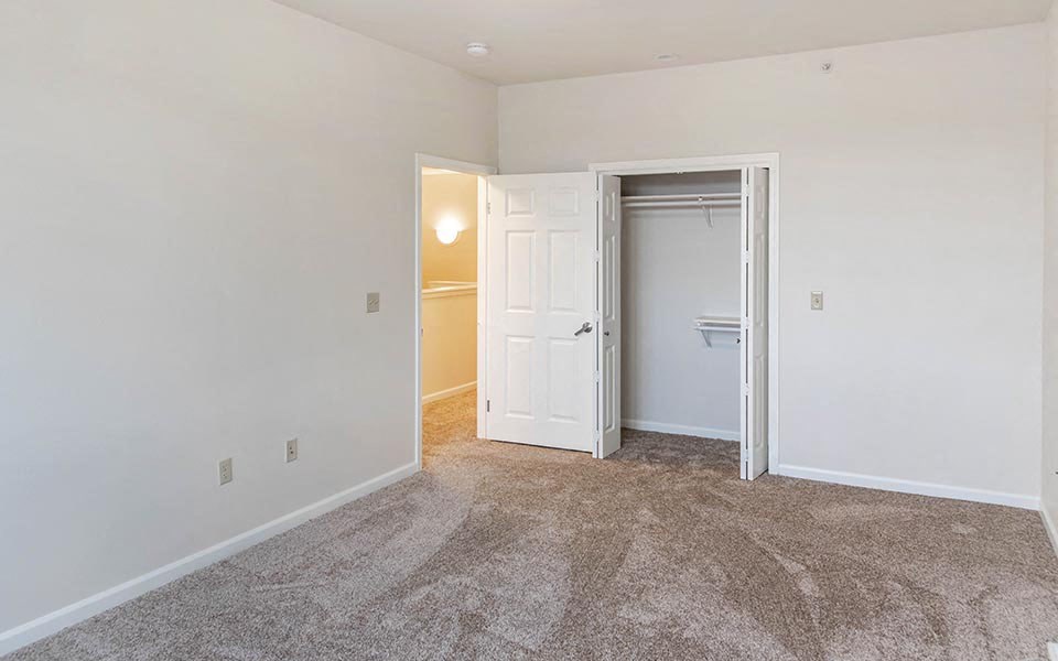 a bedroom with a closet and a door to a bathroom