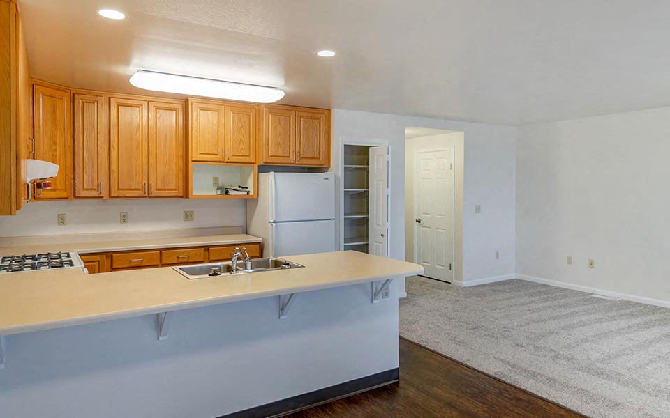 an empty kitchen with a sink and a refrigerator