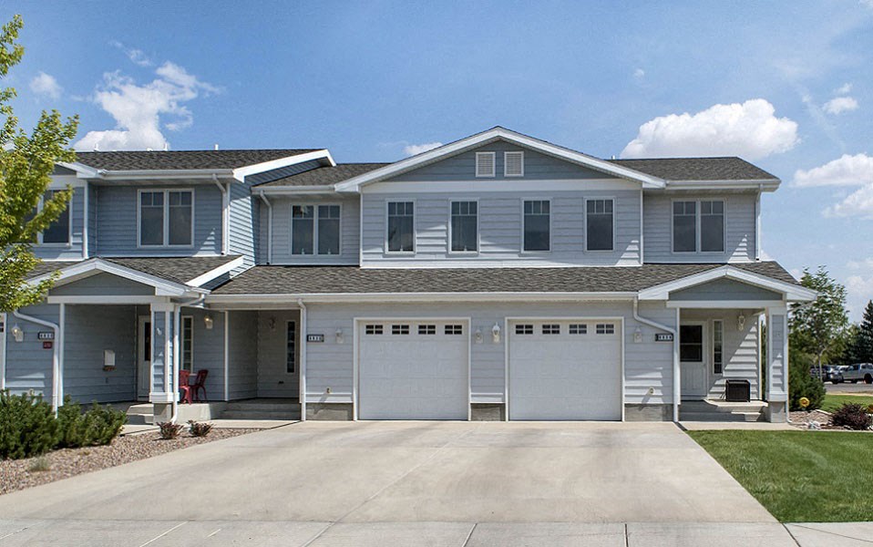 a blue house with two garage doors