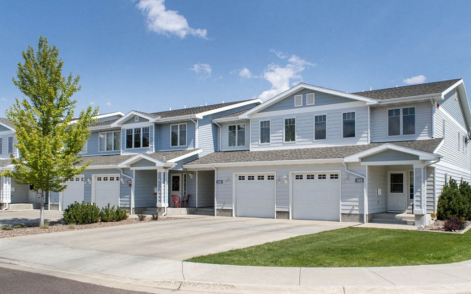a blue house with white shutters and a driveway